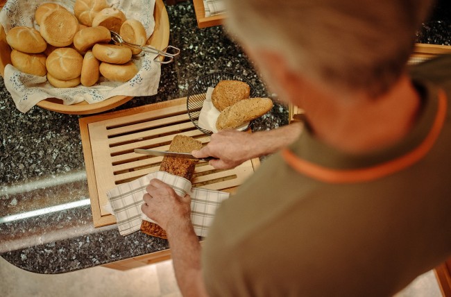 Brot schneiden beim Frühstücksbuffet