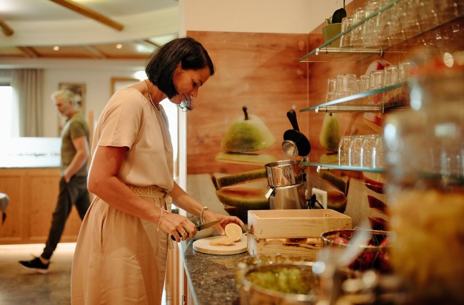 Frau bedienst sich am Frühstücksbuffet