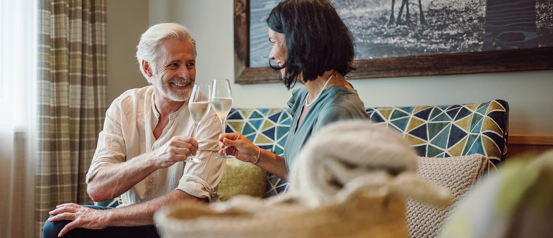 Willkommensgetränk für unsere Gäste - Paar stößt an mit einem Glas Sekt in der Lobby